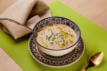 Вершковий суп з маслом у візерунковій мисці на зеленій серветці — стокове фото
