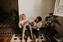 Romantico uomo e donna seduti sul pavimento a casa insieme — Foto stock