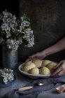 Mãos de colheita de cozinheiro irreconhecível tomando prato com pães. — Fotografia de Stock
