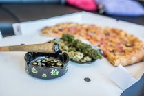 Maconha ou planta de cannabis e uma pizza — Fotografia de Stock