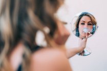 Young woman smoking a cannabis joint in the mirror — Stock Photo