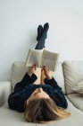 Ragazza bionda assorbita con la lettura in pullman a casa — Foto stock