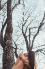 Frau sitzt mit geschlossenen Augen auf Baum — Stockfoto