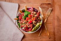 Tigela de salada vegetal saborosa com abacate em mesa de madeira — Fotografia de Stock