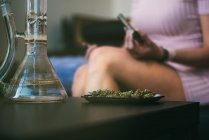 Woman preparing marijuana in a glass blunt — Stock Photo