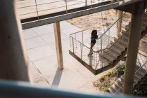 Femme penchée sur la rampe d'escalier à l'extérieur — Photo de stock