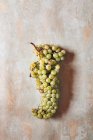 Куча зеленого винограда на потрепанной деревянной поверхности — стоковое фото