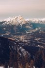 Вид з висоти засніженого гірського хребта з сяючим містом далеко в долині? — стокове фото