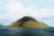 Pintoresca vista al tranquilo océano azul y a la pequeña isla verde, Islas Feroe - foto de stock