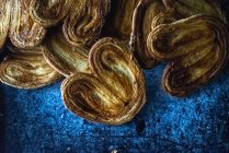 Pile of palmier cookies in pile on blue shabby background — Stock Photo