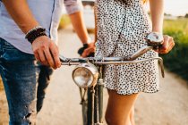 Young couple walking on rural road with bicycle on background of vintage van — Stock Photo