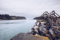 Eau calme coulant près de pierres et vieux pont par temps nuageux dans les Asturies, Espagne — Photo de stock