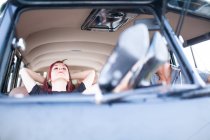 Beautiful and young woman enjoys the trip in her vintage van with some friends — Stock Photo