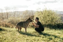 Homem brincando com cão na natureza — Fotografia de Stock