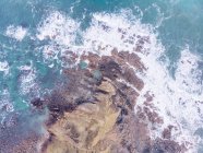 Vue imprenable sur les éclaboussures d'eau de mer près de longues falaises rocheuses par temps nuageux dans les Asturies, Espagne — Photo de stock