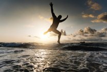 Silhouette eines Mannes, der am Strand springt — Stockfoto