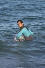 Surfista masculino surfando com prancha de surf no mar em um dia ensolarado — Fotografia de Stock