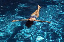 Femme couchée sur de l'eau bleue transparente — Photo de stock