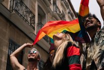 Gruppo di amici con una bandiera di orgoglio gay nella città di Madrid — Foto stock
