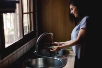 Mulher lavando salada na pia — Fotografia de Stock
