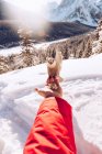 Mano de la cosecha del viajero con semillas alimentando poco pájaro salvaje en la naturaleza con nieve y luz solar en el fondo, Canadá - foto de stock