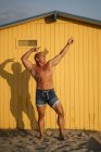 Muskulöser älterer Mann posiert vor gelbem Hintergrund — Stockfoto