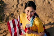 Lässiges Mädchen mit Getränk auf Sand — Stockfoto
