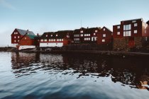 Grandes casas tradicionales marrones en la orilla del mar, Islas Feroe - foto de stock