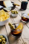 Served cocktails and snacks on wooden table — Stock Photo