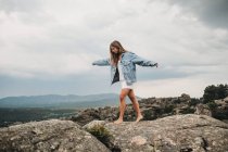 Frau springt über Riss auf Steine — Stockfoto
