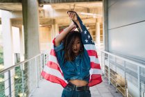 Jovem mulher em roupas de ganga segurando bandeira da América — Fotografia de Stock