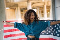 Молода жінка в джинсового одягу тримає прапор Америки — стокове фото