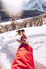 Mano de la cosecha del viajero con semillas alimentando poco pájaro salvaje en la naturaleza con nieve y luz solar en el fondo, Canadá - foto de stock