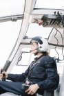 Pilota donna concentrato seduto e operante in elicottero — Foto stock