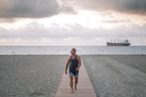 Homem velho forte posando na praia — Fotografia de Stock