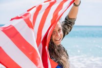 Uma menina posando na praia com bandeira EUA. — Fotografia de Stock
