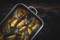 Смажені золоті хрусткі картопляні клини в сковороді на дерев'яному столі — стокове фото