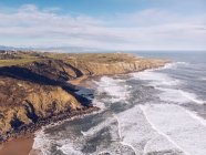 Atemberaubende Aussicht auf Meerwasser Spritzen in der Nähe lange felsige Klippe an bewölkten Tag in Asturien, Spanien — Stockfoto