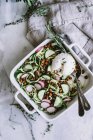 Zucchini salad in patterned dish with spoon — Stock Photo
