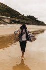 Persona che cammina sulla costa bagnata — Foto stock