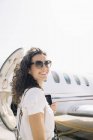 Усміхнена жінка мандрівник, що вилітає з літака в аеропорту — стокове фото