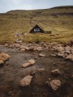 Tradicional casa rural solitaria en la meseta en el lago en las Islas Feroe - foto de stock