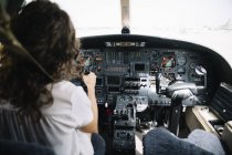 Уверенная брюнетка женщина, управляющая самолетом — стоковое фото