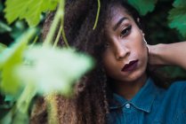 Donna afroamericana in piedi in foglie verdi — Foto stock