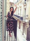 Schöne junge Frau steht auf Balkon in der Stadt — Stockfoto