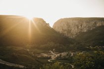 Дивовижний вид на яскраве сонце, що сяє над красивими горами та мальовничою долиною — стокове фото