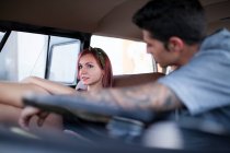 Beautiful and young woman enjoys the trip in her vintage van with some friends — Stock Photo