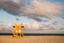 Petite cabine de sauvetage debout sur une plage de sable fin par temps nuageux à Miami — Photo de stock