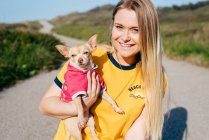 Girl with small Chihuahua in sunlight — Stock Photo