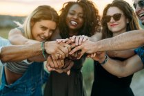 Gruppe junger Erntehelfer lächelt und hält die Hände zusammen, während sie Zeit in der Natur verbringen — Stockfoto